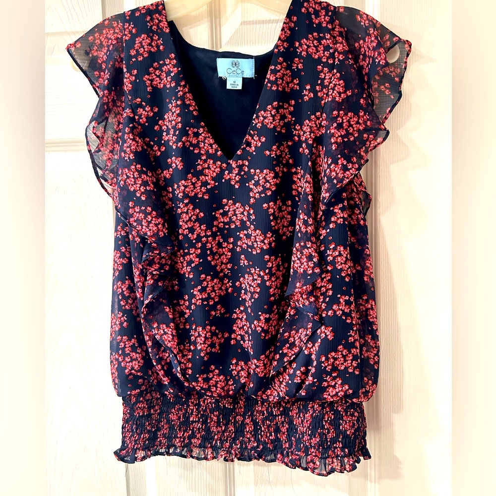 Flouncy pink/navy blouse with front panels and cap sleeves.